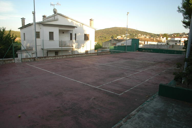 PISTA DE TENIS CON LA CASA AL FONDO